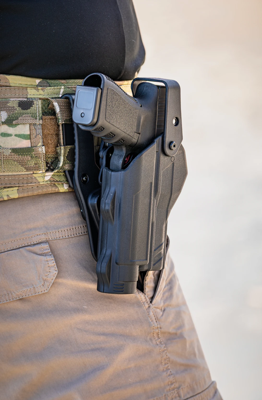 Handgun in tactical holster on belt.